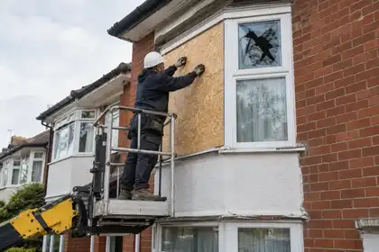 Illustrative Burglary Window Repairs scene: Boarding Up Engineer Secures Broken Bay Window.