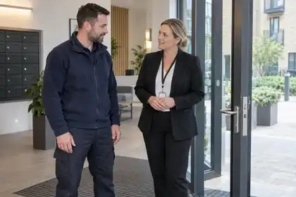 Locksmith and building representative discussing a communal entrance lock.