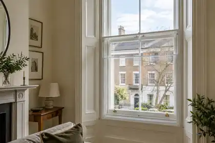 Vertical sliding secondary glazing behind a sash window